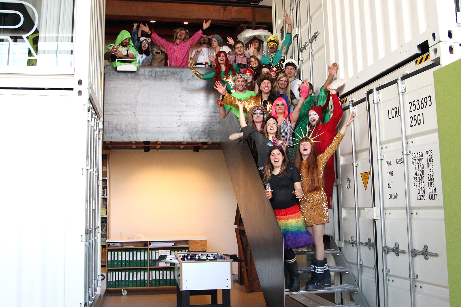 Photo Salon K all employees dressed up on stairs hands up