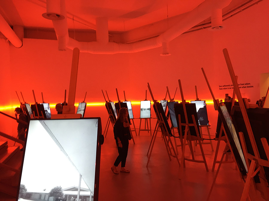 photo exhibition hall red light wooden easels with illuminated black and white pictures