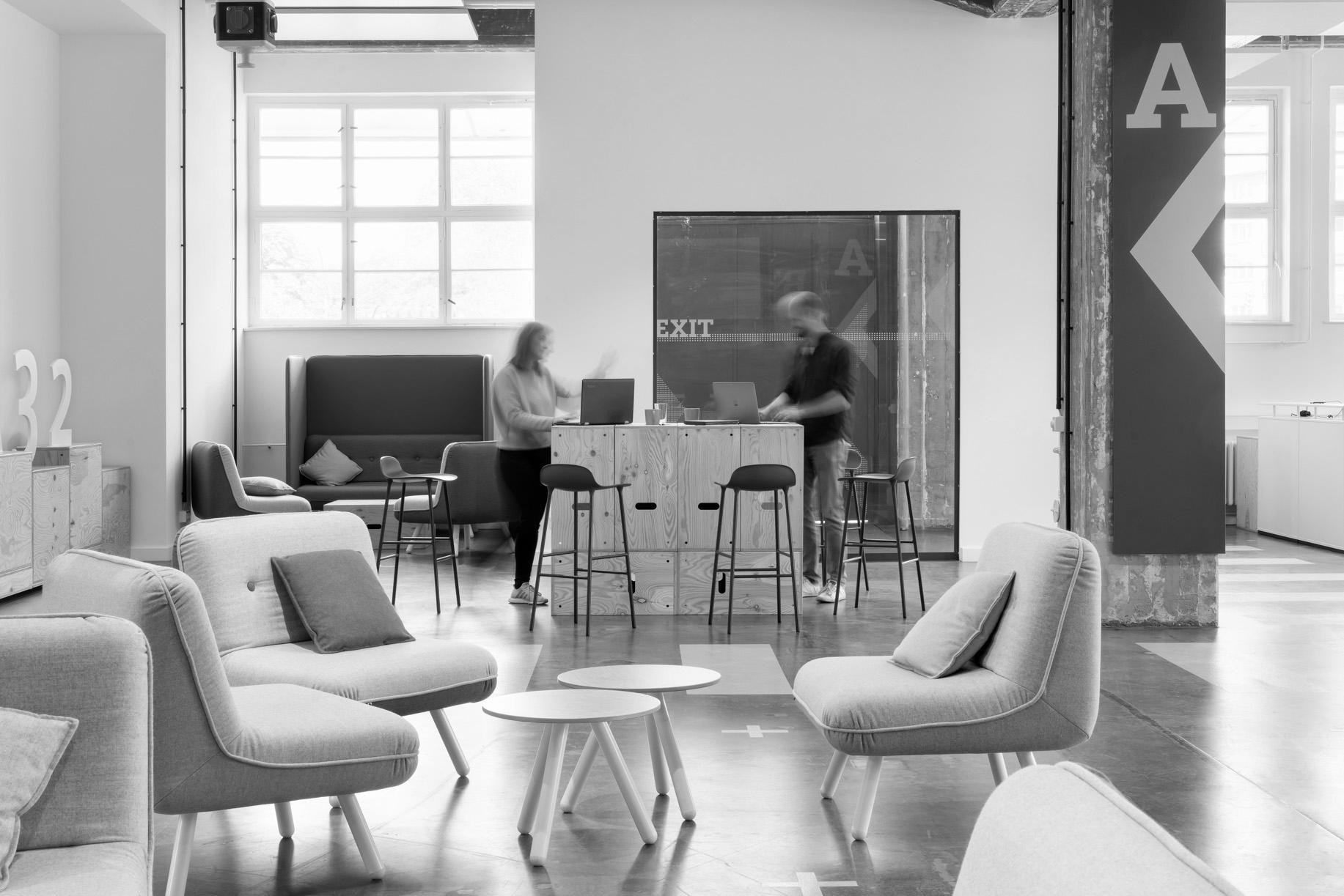 very modern office two people standing bar table laptop