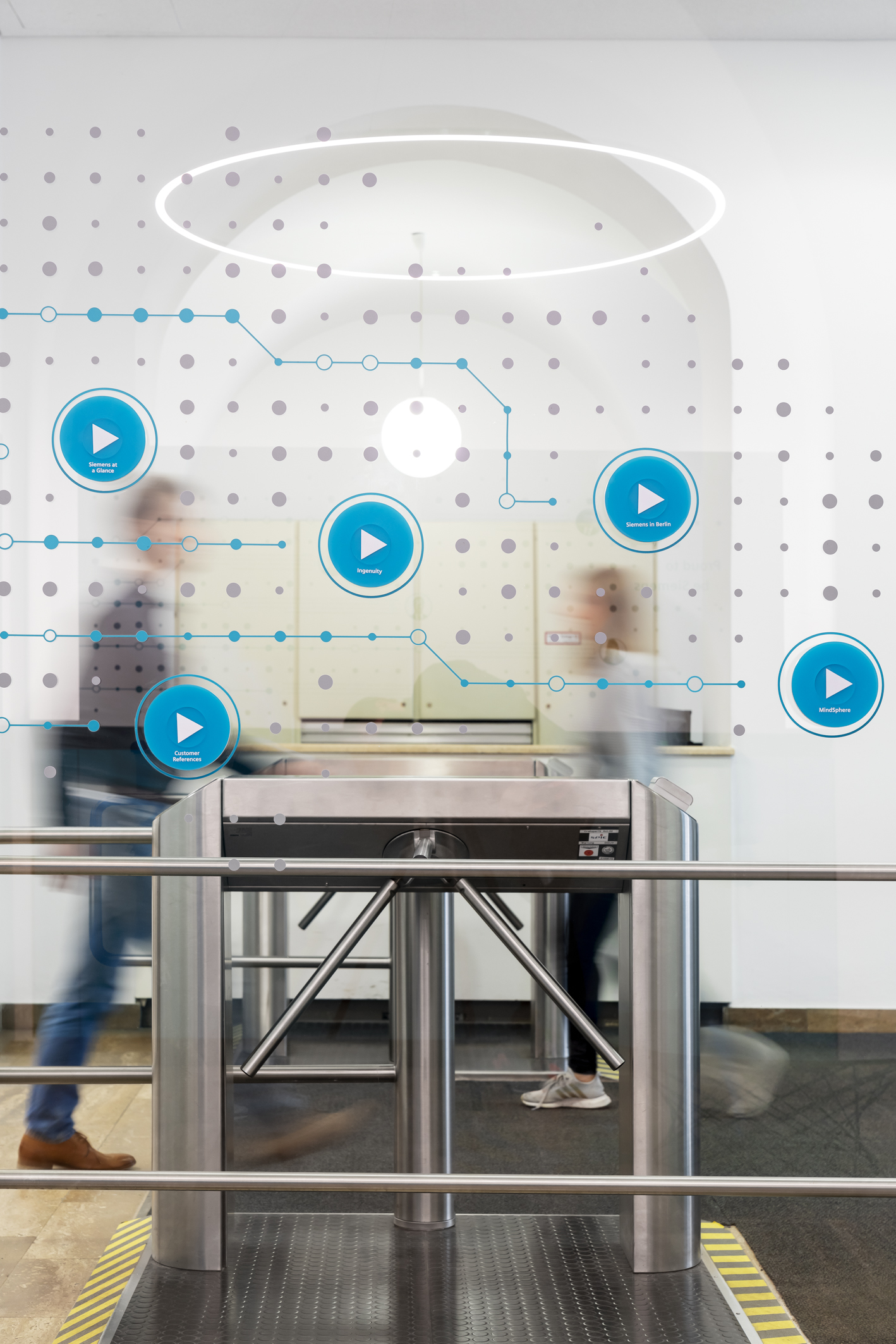 Glass wall blue buttons to interact with persons in the background