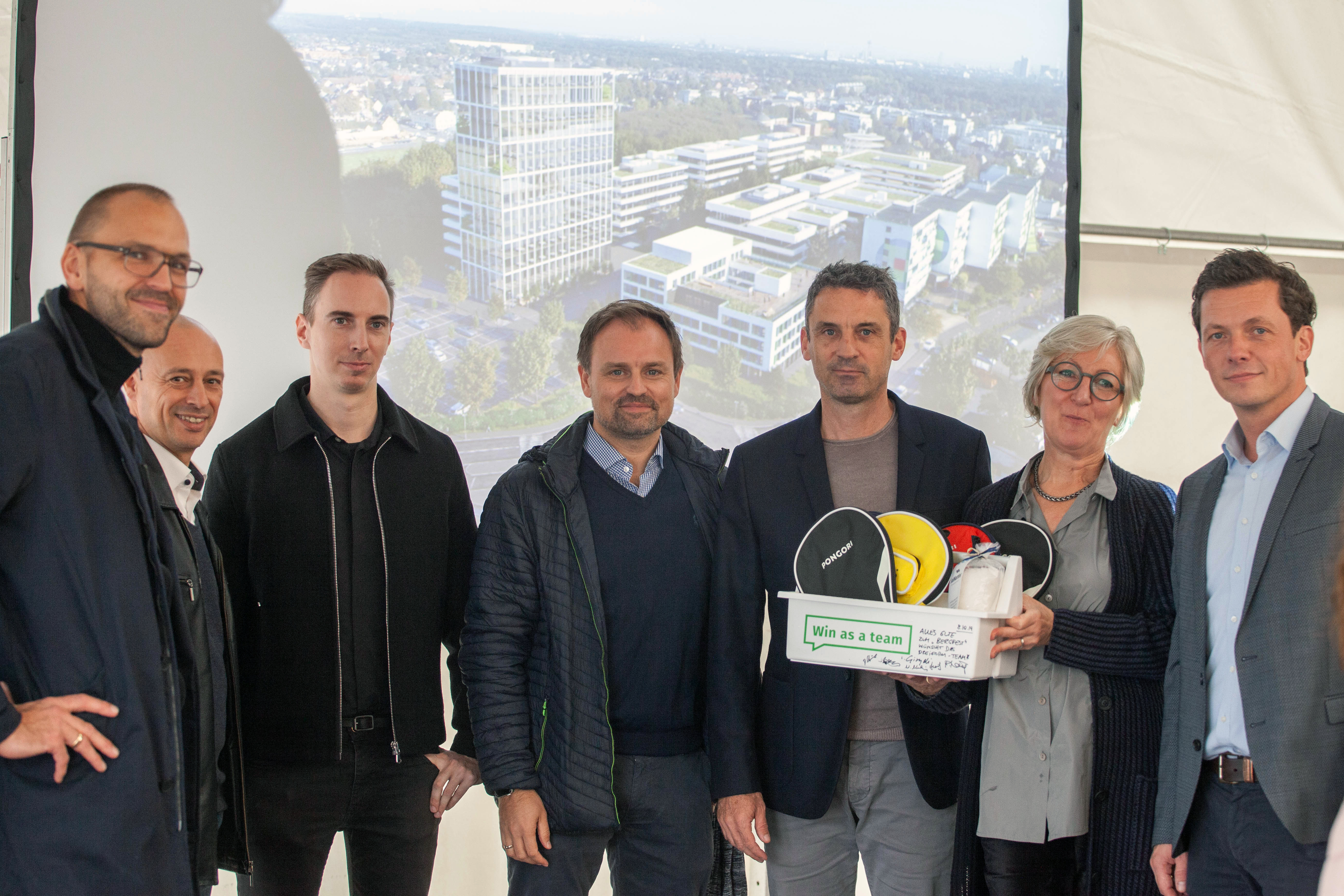 Foto Gruppenbild Geschenkübergabe Bergfest dreiform Wolters Kluwer Brot Salz Tischtennisschläger win as a team