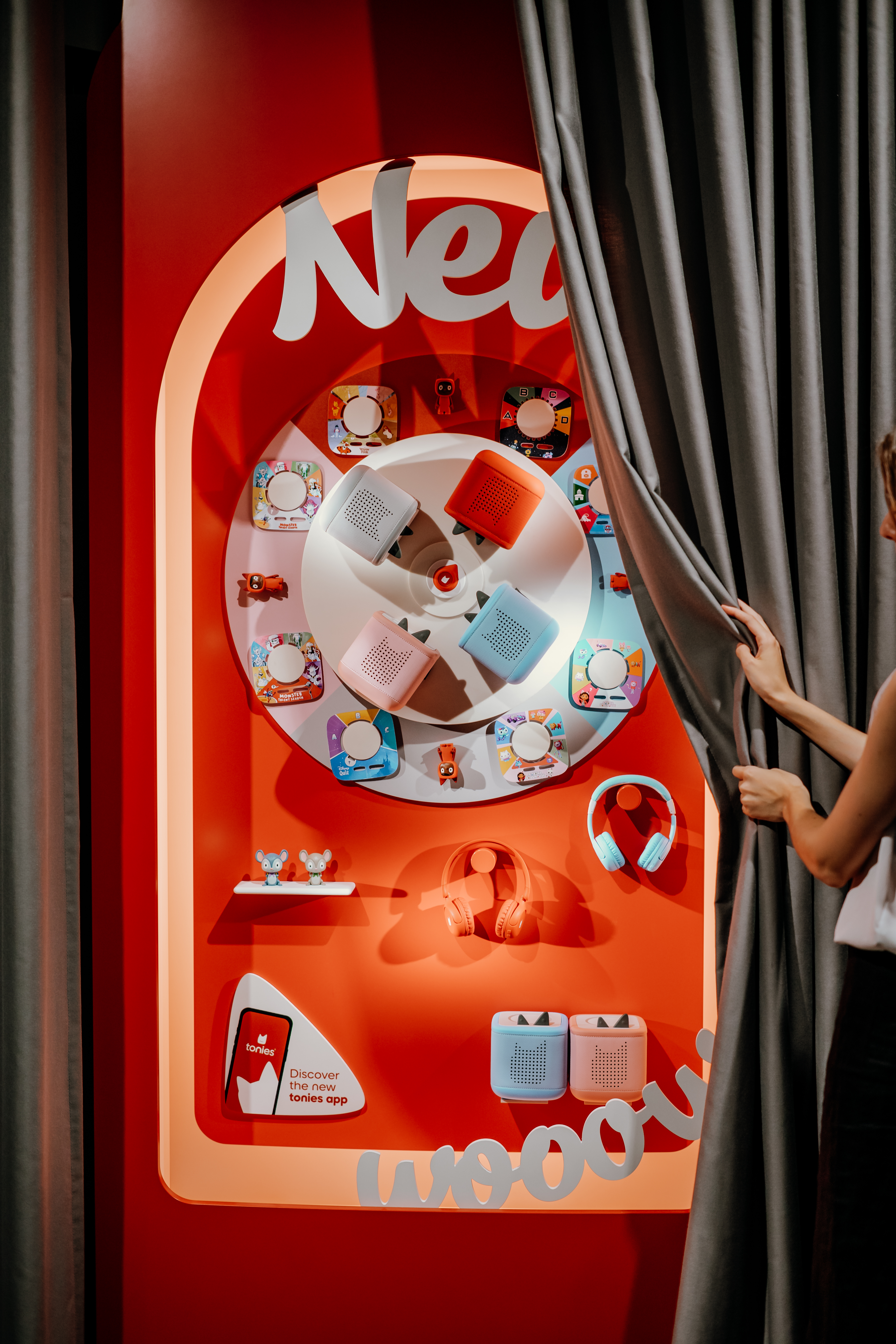A woman pulls aside a curtain to reveal the release of the Toniebox 2.