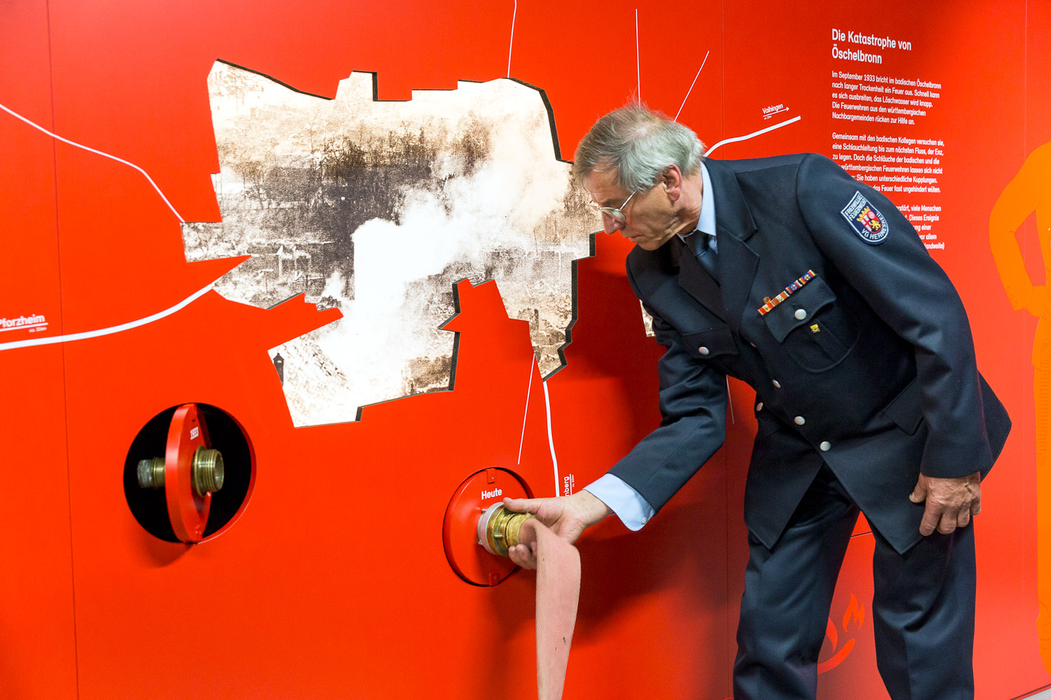 Firefighter connects modern water hose with connecting piece on the wall