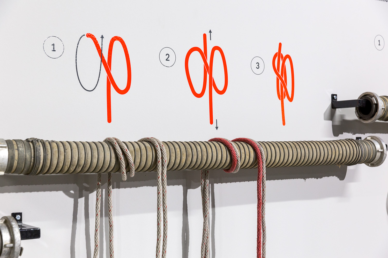 Ropes hang from wall bracket. A simple graphic above shows how to tie a knot